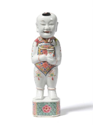 Lot 290 - A Chinese Porcelain Figure of a Standing Boy, 18th century, holding a vase of two flowers, standing