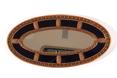 Lot 526 - ~ A 19th Century Giltwood Oval Mirror, the egg and dart moulded frame surrounding a blue glass...