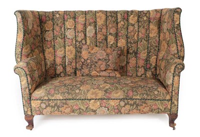 Lot 548 - A Victorian Wing Back Sofa, late 19th century, recovered in floral fabric with rounded arms and...