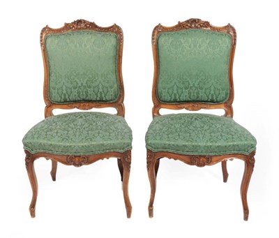 Lot 568 - ~ A Pair of Late 19th Century Carved Walnut Side Chairs, in Louis XV style, recovered in green...