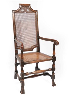 Lot 571 - ~ A 1920s Walnut Armchair, in 17th century style, the cane back support and seat with scrolled hand