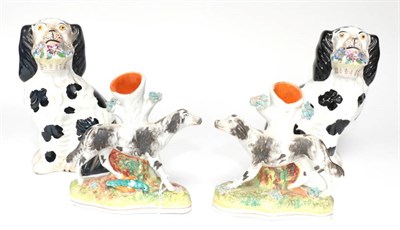 Lot 1257 - A Pair of Staffordshire Pottery Spaniels, circa 1900, seated holding a basket of flowers in...