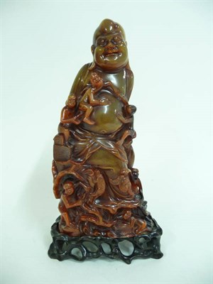 Lot 326 - A Chinese Carved and Stained Buffalo Horn Figure of Hotei, early 20th century, the corpulent...