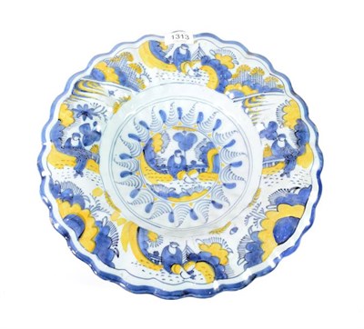 Lot 1313 - A Delft Dish, circa 1680, of fluted circular form, painted in Kraak style in blue and ochre...