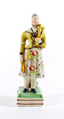 Lot 1320 - A Pearlware Figure of a Girl Juggler, circa 1820, standing holding three clubs on a rectangular...