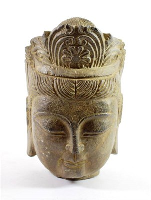 Lot 1411 - A Chinese Carved Stone Head of Buddha, in archaic style, with foliate head dress, 26cm high