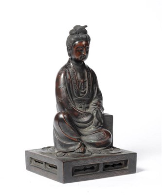 Lot 340 - A Chinese Bronze Figure of Guanyin, 18th century, the seated figure in flowing robes leaning on...