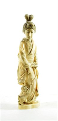 Lot 1456 - A Japanese Ivory Okimono, Meiji period, in the form of a girl wearing traditional robes, a dog...