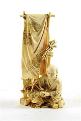 Lot 1465 - A Japanese Ivory Okimono, Meiji period, as a craftsman decorating a banner, 16cm high