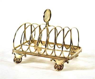 Lot 1503 - {} A George IV Silver Toast Rack, James Arthur, London 1828, rounded rectangular on four shell...