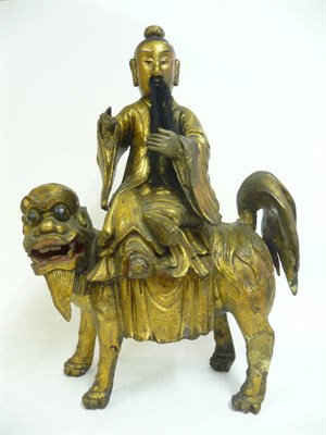 Lot 349 - A Chinese Carved Gilt and Painted Hardwood Figure of a Traveller, in Ming style, wearing...