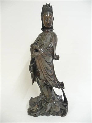 Lot 357 - A Chinese Carved Hardwood Figure of  Guanyin, 19th century, standing in flowing robes with...