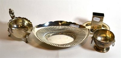 Lot 12 - A silver oval shaped bowl; a silver sugar bowl; a silver match box holder/tray; and a silver...