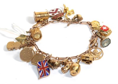 Lot 93 - A charm bracelet, stamped '9C' hung with twenty two charms, mainly 9 carat gold