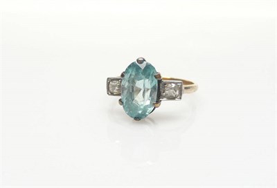 Lot 384 - A Blue Zircon and Diamond Three Stone Ring, an oval cut blue zircon claw set and flanked by two old