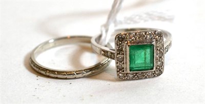 Lot 320 - A band ring stamped 'PLATINUM', finger size N; and an emerald and diamond cluster ring stamped...