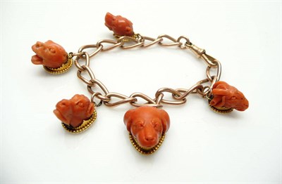 Lot 403 - A 9 Carat Rose Gold Curb Bracelet Hung with Five Coral Charms, the charms comprise one ram's...