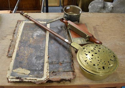 Lot 1118 - A pierced brass bed warmer; a bronze skillet; a pill roller; and a group of leather panels