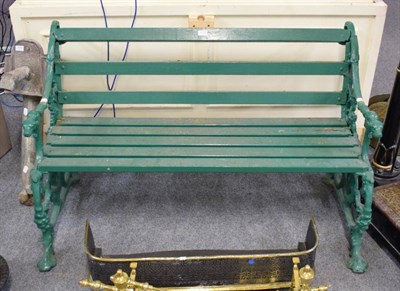 Lot 1172 - A Victorian green painted, cast iron, wooden slatted garden bench, the scroll cast arms terminating
