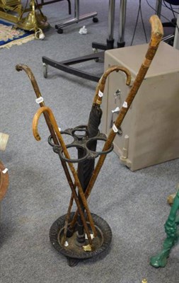 Lot 1175 - A Victorian cast iron, four division umbrella stand, with four walking sticks and a partridge...