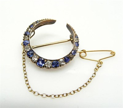 Lot 423 - A Sapphire and Diamond Crescent Brooch, alternating old cut sapphires and diamonds graduate through