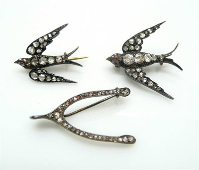 Lot 424 - Two Swallow Brooches, the graduated birds in flight set with ruby eyes, the larger with old...