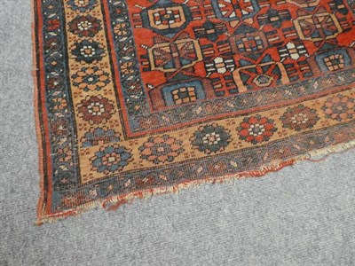 Lot 1235 - An Indo-Persian rug, the central brick-red field with three columns of geometric medallions, within