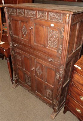 Lot 1344 - A 20th century carved oak cupboard, two doors over a dressing slide, above a further pair of doors