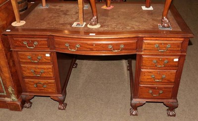 Lot 1353 - A reproduction leather inset knee hole desk