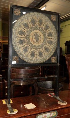 Lot 1355 - A 19th century ebonised firescreen, with glazed panel enclosing an 18th century silk work panel