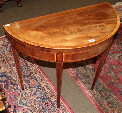 Lot 1360 - A George III crossbanded mahogany demi-lune fold over tea table