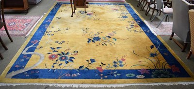 Lot 1396 - A Chinese carpet circa 1920, the gold field with semi naturalistic plants and trees enclosed by...