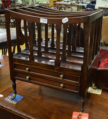 Lot 1428 - A mahogany four division Canterbury fitted with two base drawers and moving on brass casters