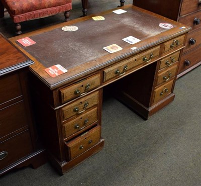 Lot 1434 - An early 20th century oak knee hole, leather inset desk