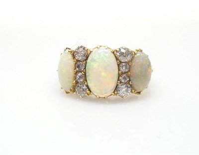 Lot 456 - A Victorian Opal and Diamond Ring, three oval cabochon opals spaced by rows of four graduated...