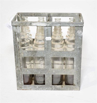 Lot 176 - A Vintage Essolube Metal Cage, containing eight Essolube 1 quart clear glass oil bottles, 37cm...