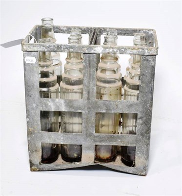 Lot 180 - A Vintage Essolube Metal Cage, containing eight Essolube 1 quart clear glass oil bottles, 37cm...