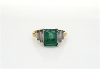 Lot 477 - An Emerald and Diamond Ring, the emerald-cut emerald is flanked by a pair of graduated baguette cut