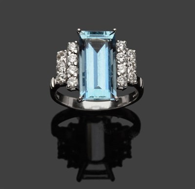 Lot 487 - An 18 Carat White Gold Aquamarine and Diamond Cluster Ring, the step cut aquamarine flanked by...