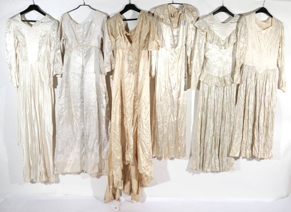 Lot 2100 - Early 20th Century Wedding Dresses, comprising a cream silk dress with long sleeves, wriggle...