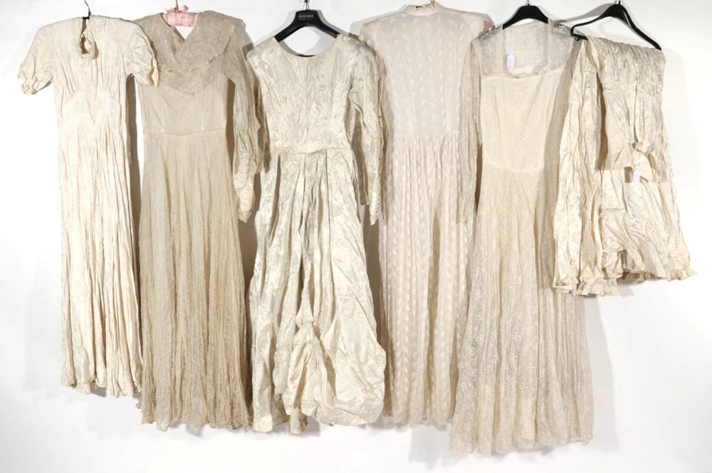 Lot 2101 - Early 20th Century Wedding Dresses, comprising a cream long sleeved silk damask type wedding dress