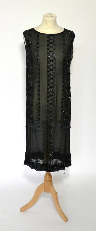 Lot 2111 - 1920s Black Beaded Sleeveless Dress, the chiffon ground embellished with a geometric design of...