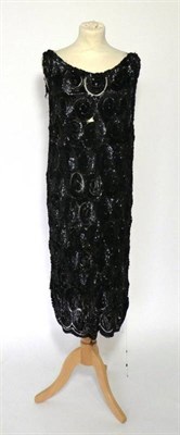 Lot 2114 - 1920s Black Sequinned Sleeveless Dress, the net ground densely embellished with large spirals...