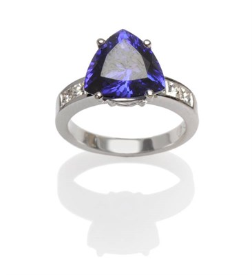 Lot 501 - A Tanzanite and Diamond Ring, a trilliant cut tanzanite with three princess cut diamonds...