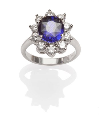 Lot 502 - A Sapphire and Diamond Cluster Ring, an oval cut sapphire within a border of round brilliant...