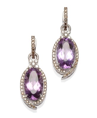 Lot 504 - A Pair of Amethyst and Diamond Drop Earrings, an oval cut amethyst within a border of round...