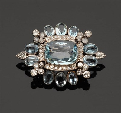 Lot 521 - An Aquamarine and Diamond Brooch, a cushion cut aquamarine within a lozenge shape frame of oval cut