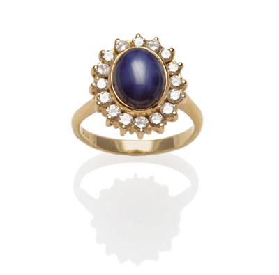 Lot 551 - A Synthetic Star Sapphire and Diamond Cluster Ring, the cabochon sapphire within a border of...