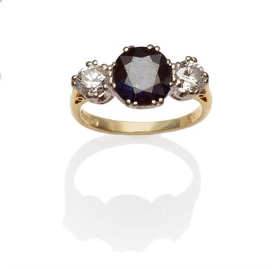 Lot 552 - An 18 Carat Gold Sapphire and Diamond Three Stone Ring, a round brilliant cut sapphire flanked by a