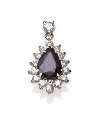 Lot 553 - An 18 Carat White Gold Sapphire and Diamond Cluster Pendant, a pear cut sapphire within a border of